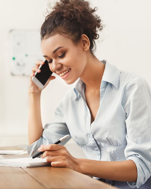 Telefonservice-Mitarbeiterin bei der Arbeit im Gespräch am Telefon