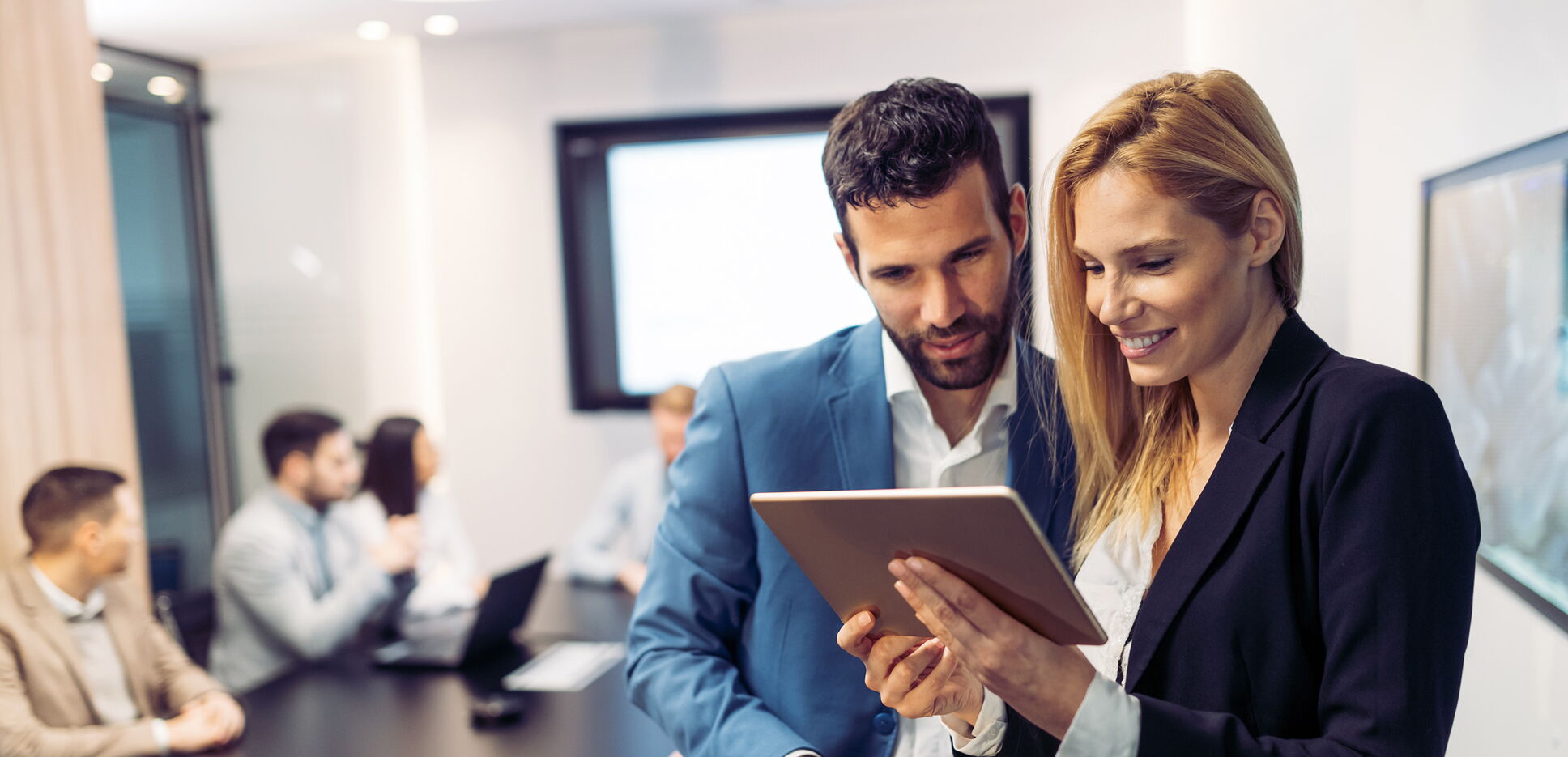 Der Equal Pay Award 2022 – Geschäftsleute diskutieren bei der Nutzung eines digitalen Tablets im Büro