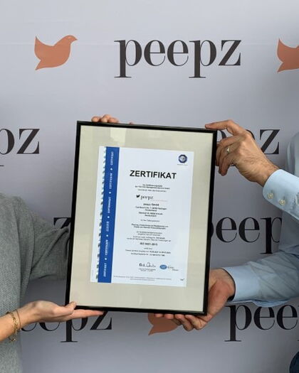 Stella und Moritz halten das ISO 9001 Zertifikat