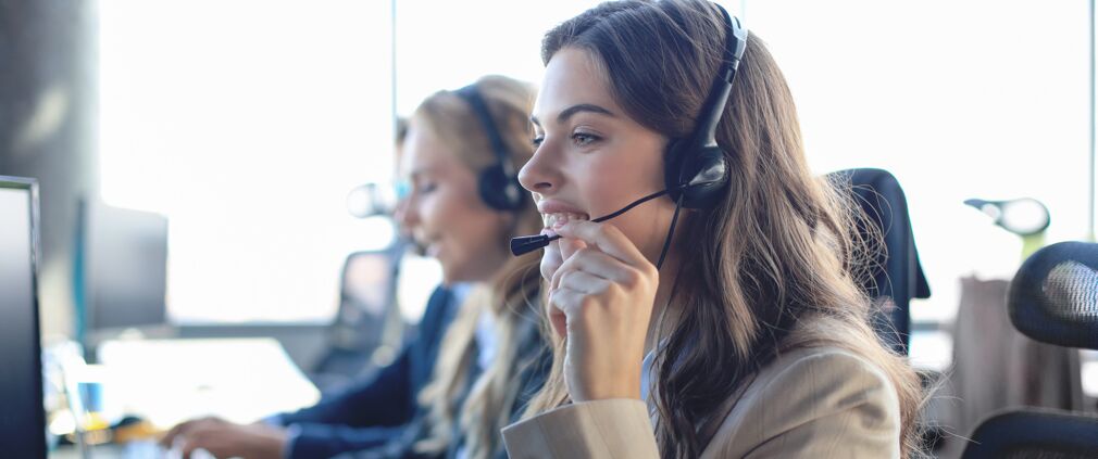 Weibliche Kundenbetreuerin mit Headset im Telefonservice