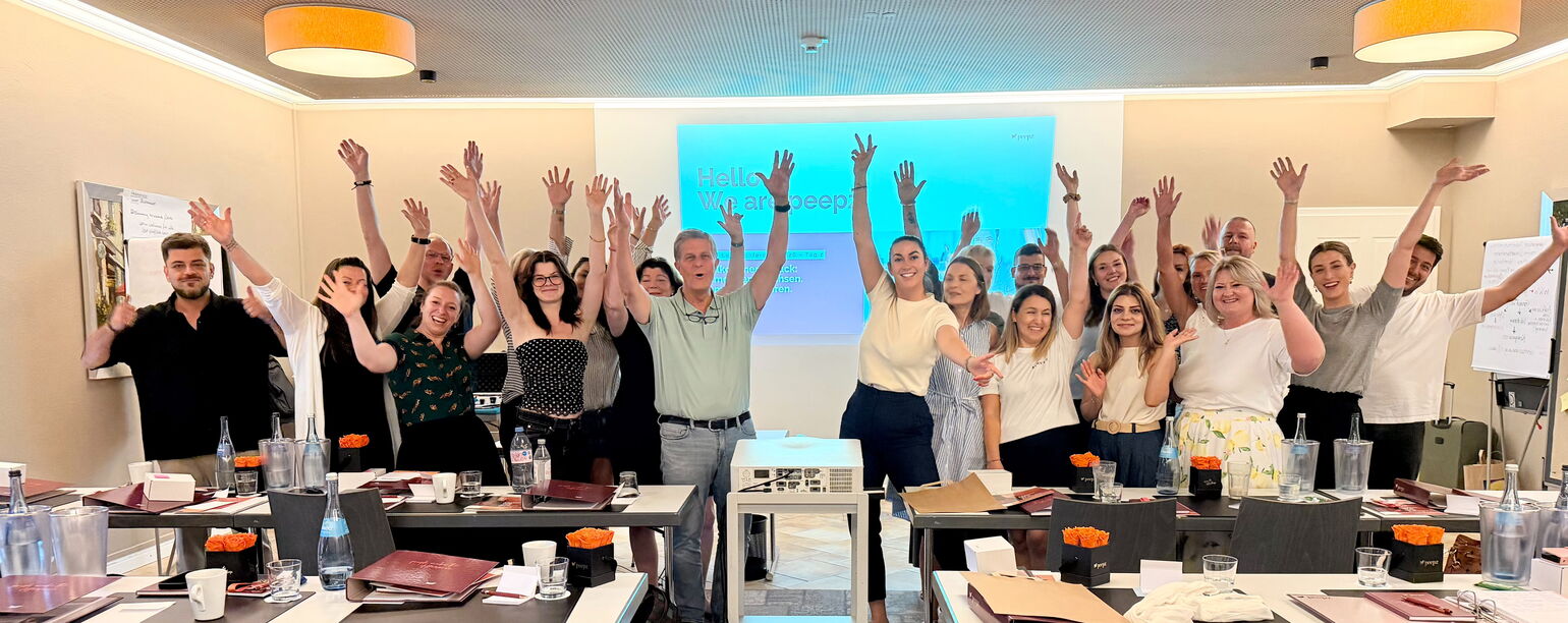 Gruppenfoto der jubelnden Führungskräfte der Team Lead Conference 2026 im Tagungsraum.