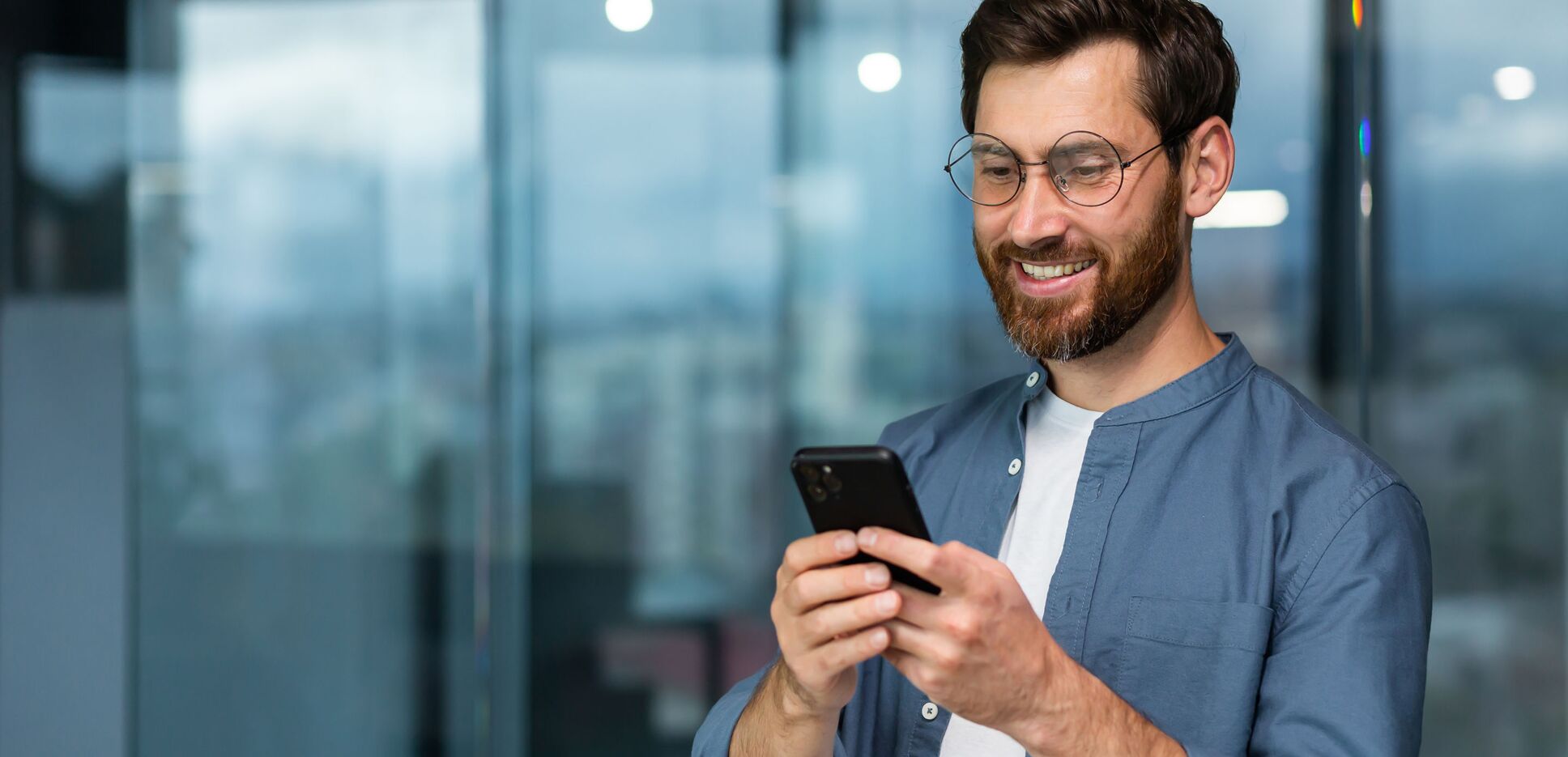 Entscheider liest lächelnd die News des Personaldienstleisters peepz auf seinem Smartphone