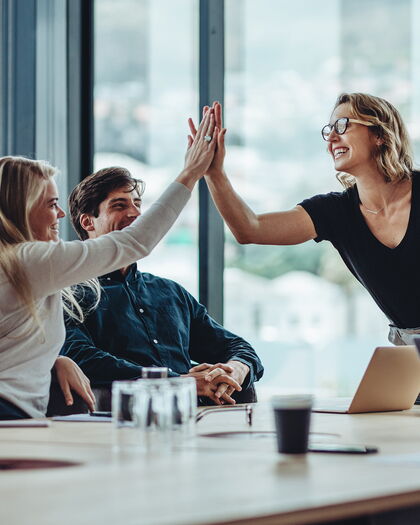 Team feiert mit einem High-Five das wissenschaftlich validierte 1,5°C-Klimaziel und die SBTi-Zertifizierung.