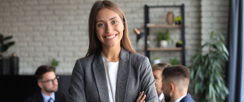 Gleichstellung bei peepz – Geschäftsfrau mit ihren Mitarbeitern im Hintergrund