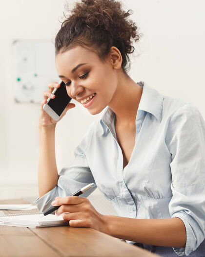 Telefonservice-Mitarbeiterin bei der Arbeit im Gespräch am Telefon