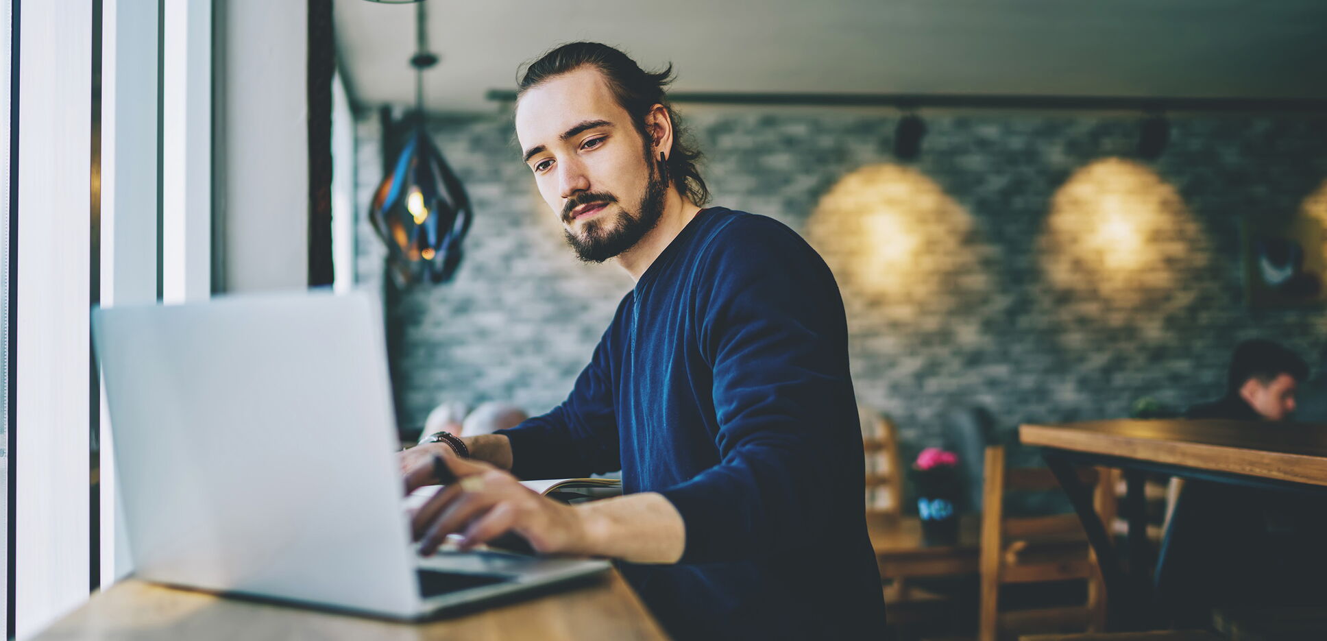 Freier Mitarbeiter arbeitet mit Laptop in Lounge