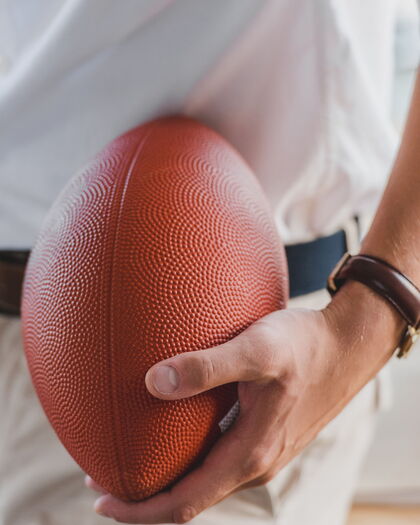 Nahaufnahme eines Mannes, der einen Rugbyball hält