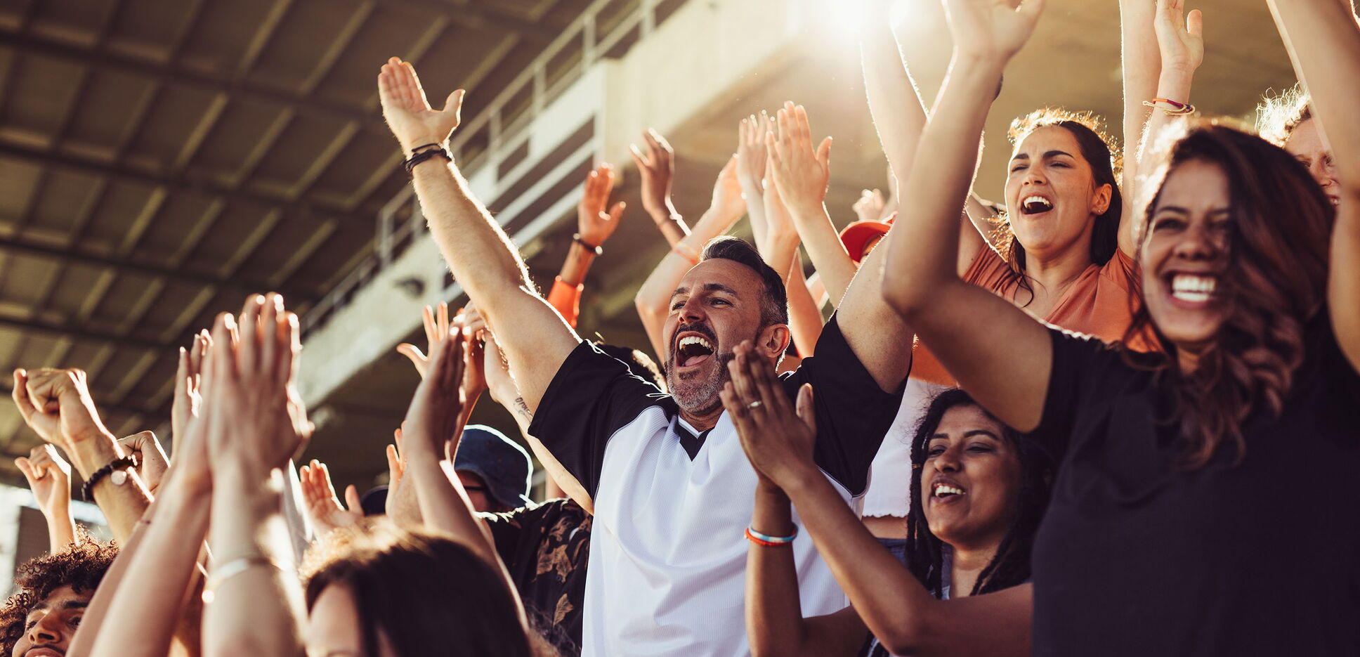 Jubelnde Sportfans bei einem Spiel im Stadion.