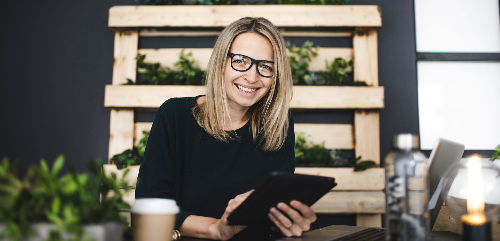 Frau arbeitet im nachhaltigen Büro an ihrem Tablet.
